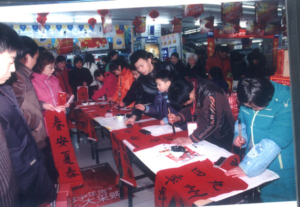 王老师在江苏苏宁电器指导学生为民写春联